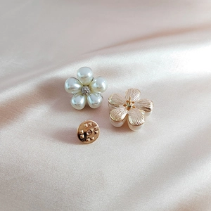 Macro detail of white pearl daisy brooch with crystal center on champagne silk fabric
