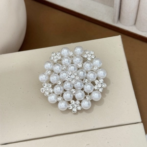 Macro view of crystal sunflower brooch with pearls and silver metal on jewelry box