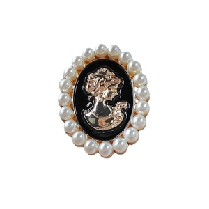 Vintage style oval cameo brooch with golden profile and white pearl border in black enamel