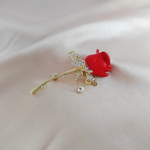 Élégante broche rose dorée avec pétales rouges, strass brillants et pendentif gouttelette