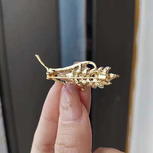 Détail du dos de la broche épi de blé doré montrant l'épingle en métal et la texture
