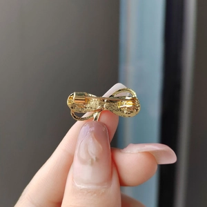 Back view of golden bow brooch with pin clasp and textured metal surface finish