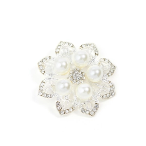 Elegant silver flower brooch with white pearls and sparkling rhinestones on white base