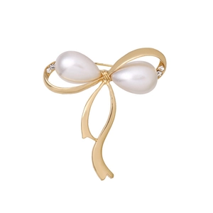 Broche de lazo dorado con perlas de lágrima y diamantes de imitación en fondo blanco