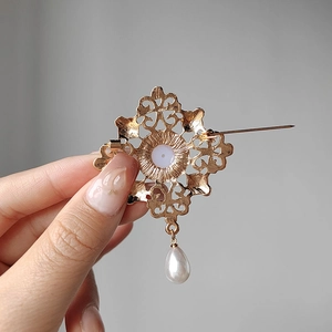 Vintage hollow gold brooch featuring a teardrop pearl and back pin closure mechanism