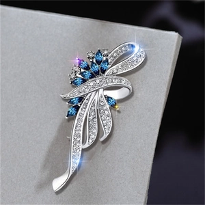 Macro shot of silver vintage ribbon brooch with blue marquise gems and white rhinestones