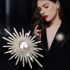 Spilla a sole dorata con perla centrale e strass scintillanti per giacche da donna