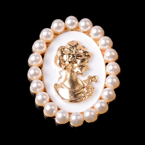 Detailansicht einer Vintage-Cameo-Brosche mit goldenem Metallsockel und weißen Perlen
