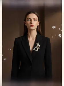Broche lapin avec cristaux blancs et nœud doré sur le revers d'un tailleur noir