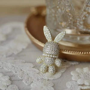 Broche lapin scintillante avec cristaux de zircone et collier de perles sur base dorée