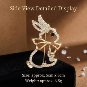 Broche lapin dorée avec cristaux blancs et yeux en pierre noire sur velours
