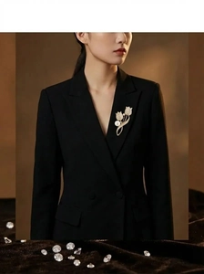 Detailed view of tulip brooch with pearls and diamonds on a black suit lapel