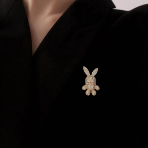 Broche lapin de luxe avec zircons scintillants et perles sur un costume noir