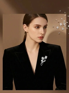 Detail of silver tulip brooch with shimmering rhinestones and white pearl on velvet suit