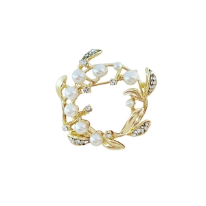 Elegant gold wreath brooch featuring white pearls and sparkling crystal rhinestones