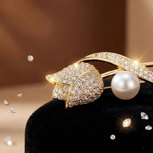 Detailed close-up of a tulip brooch featuring pave diamonds and a large pearl on black velvet