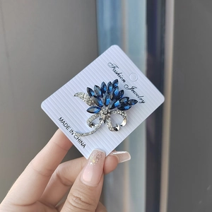 Vue détaillée de la broche fleur en argent et cristaux bleus sur sa carte de support