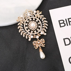 Detailansicht der Vintage-Brosche in Gold mit weißen Perlen und funkelnden Strasssteinen
