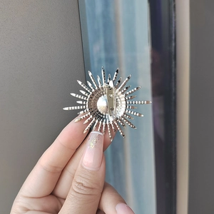 Silver sunflower pearl brooch featuring radiant sunburst metal rays and secure pin clasp
