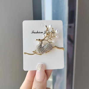 Elegant reindeer brooch with sparkling rhinestones and white pearls in gold finish