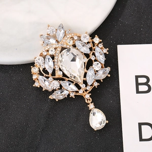 Nahaufnahme der Vintage-Goldbrosche mit birnenförmigen Kristallen und hängendem Anhänger