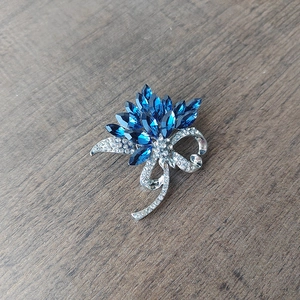 Détail de la broche fleur en cristal avec pierres marquises bleues et ruban argenté