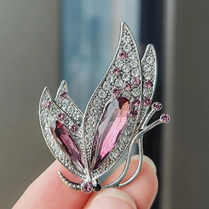 Vue macro de la broche papillon argentée avec cristaux violets et strass scintillants