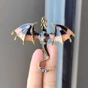Detailed dragon brooch with colorful gradient enamel wings held to show its actual size