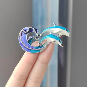 Spilla delfino smaltata con onde blu e cristalli viola su base in metallo argento