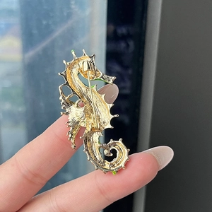 Vintage seahorse brooch with green enamel details and secure golden pin back closure