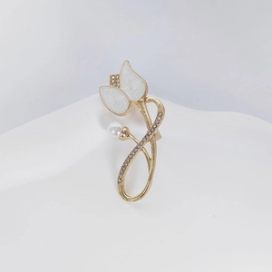 Détail broche tulipe avec base dorée, pétales émail blanc, perle et strass étincelants