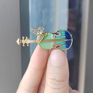 Vintage gold violin brooch with blue and green enamel and a rhinestone butterfly