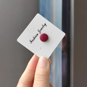Detailed close-up of a matte dark red round magnetic scarf buckle on a jewelry card