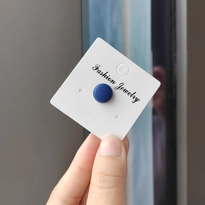 Detail of a matte navy blue magnetic hijab brooch on a white fashion jewelry card