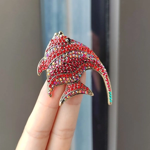Macro shot of tropical angelfish brooch featuring red crystals and vintage gold plating