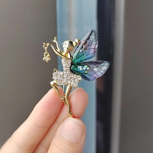 Elegante broche de hada en metal dorado con cristales blancos y alas degradadas violetas