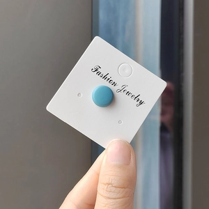 Detailed close-up of matte blue magnetic scarf clip on a white fashion jewelry card