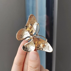 Elegant gold butterfly brooch with detailed back structure and safety pin closure