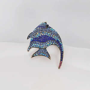 Close-up of tropical fish brooch with sparkling blue rhinestones on a metal base