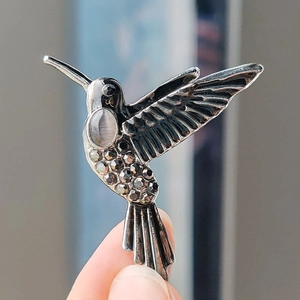 Exquisite Kolibri-Brosche mit grauem Katzenauge und Kristallen auf schwarzem Metall