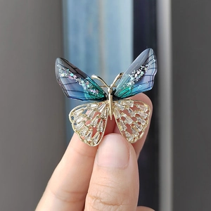Elegante broche de mariposa con alas degradadas en violeta y cristales dorados