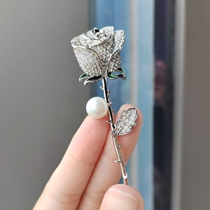 Elegant silver rose brooch with sparkling rhinestones and a large round white pearl