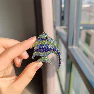 Macro view of a tropical fish brooch with vibrant blue and green rhinestones