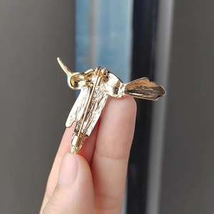 Rückansicht der Kolibri-Brosche in Gold mit dem sicheren Drehverschluss für Kleidung