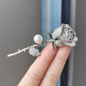 Elegant silver rose brooch with sparkling rhinestones, white pearl, and green enamel finish