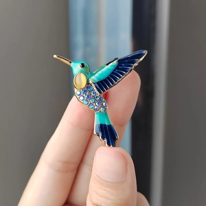 Detailansicht der Kolibri-Brosche mit farbiger Emaille und eingelegten Strasssteinen