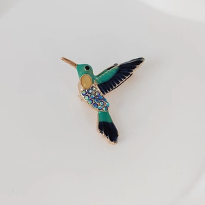Detailansicht der Kolibri-Brosche mit grüner Emaille und blauen Kristallsteinen