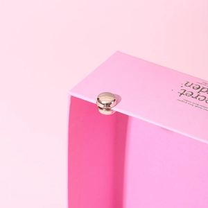 Vue macro d'une boucle magnétique argentée pour écharpe sur une boîte cadeau rose