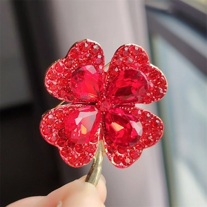 Macro shot of red clover brooch with gold plating and glittering faceted crystals
