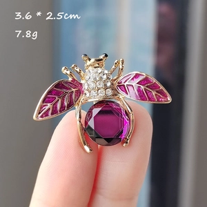 Macro d'une broche abeille avec pierre précieuse violette et ailes serties de zircons